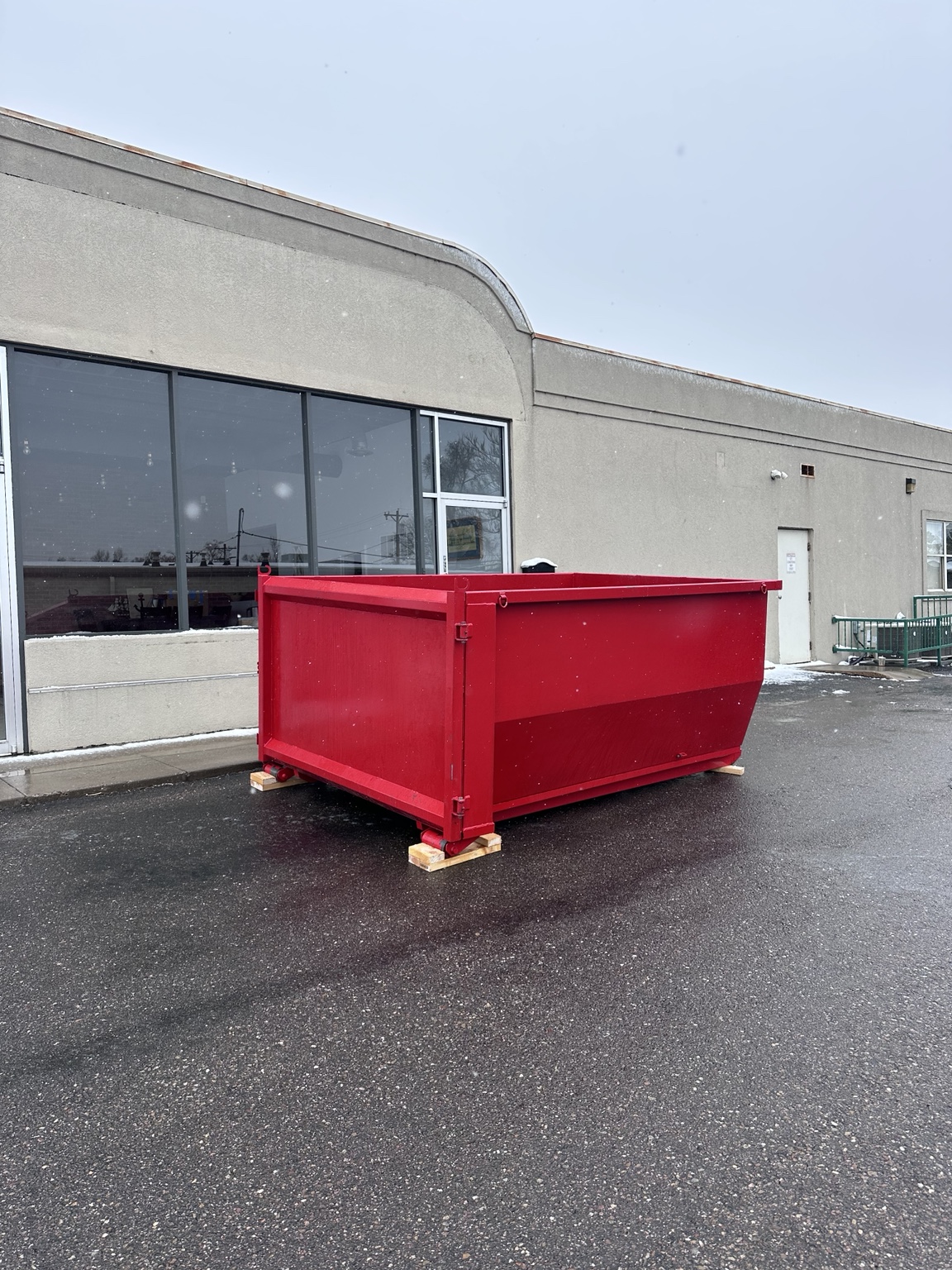 Red dumpster rental outside a commercial building