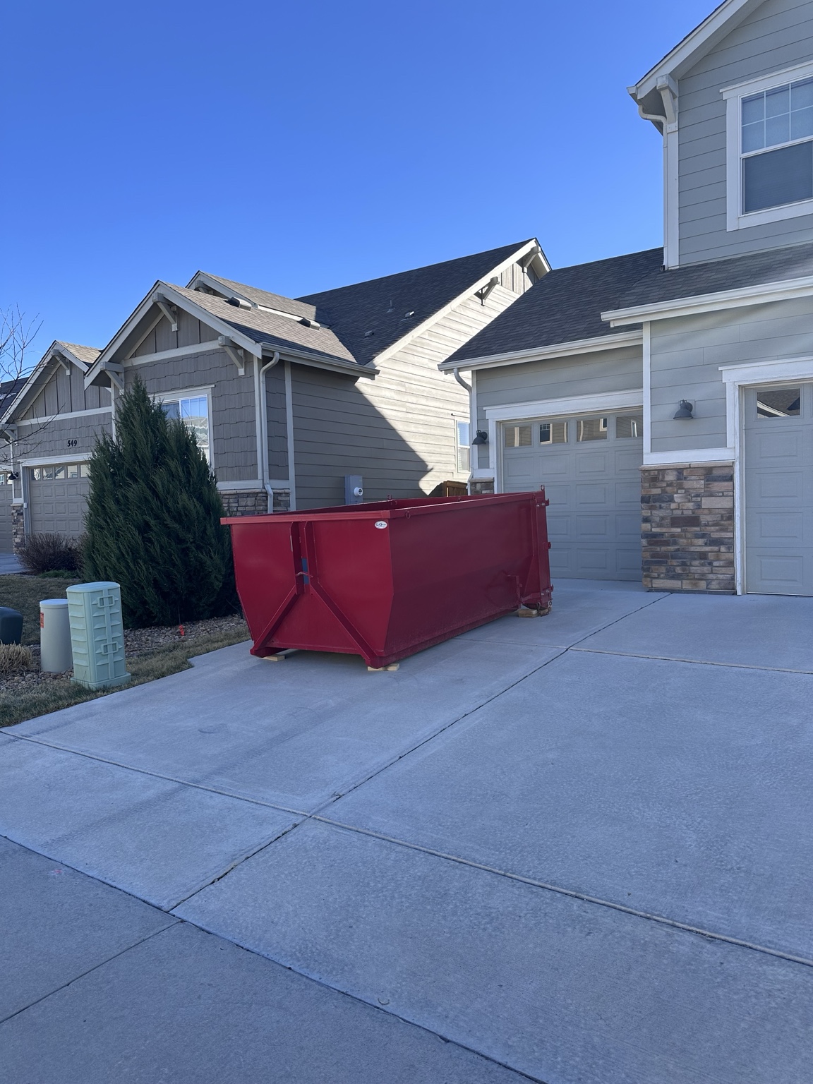 Red dumpster rental in a Northern Colorado driveway