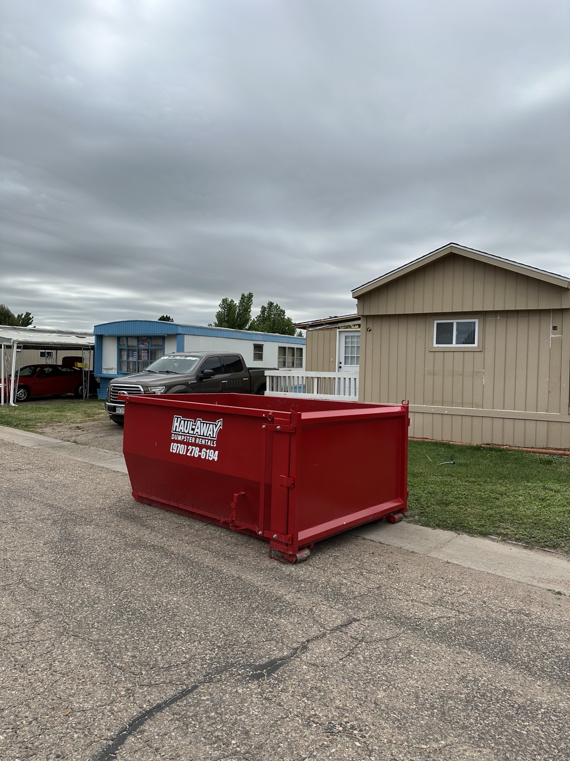 Haul Away red dumpster rental at a home cleanup
